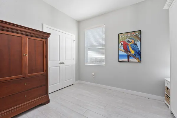 a bedroom with a bed chair and painting on the wall