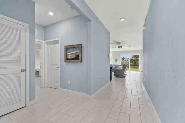 a view of a hallway with a kitchen and living room