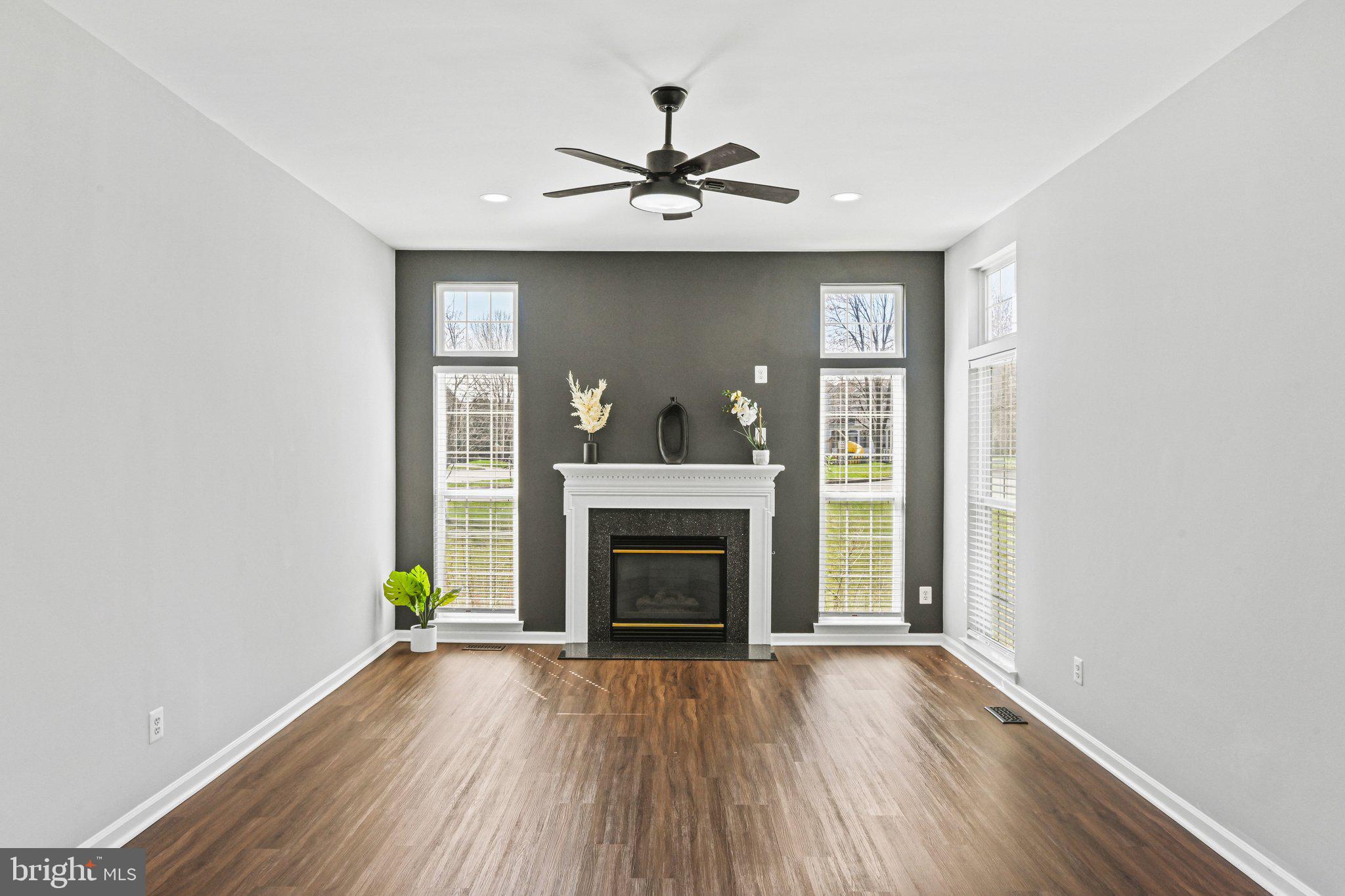 20733 Rainsboro Drive Ashburn, VA 20147 - Photo 11 of 63 a view of an empty room with wooden floor fireplace and a window