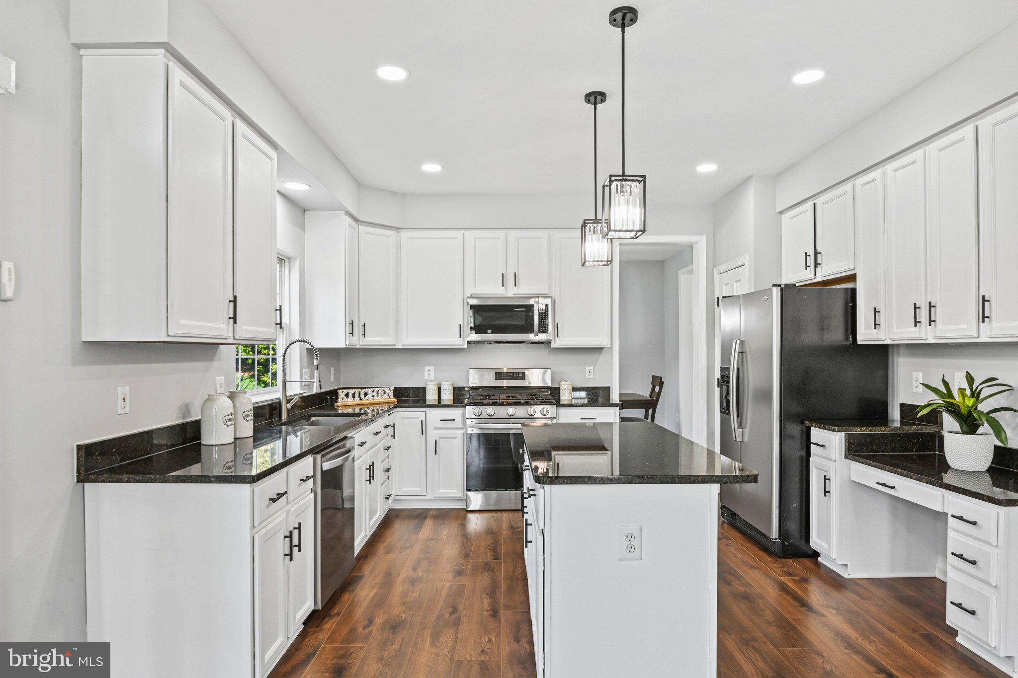 20733 Rainsboro Drive Ashburn, VA 20147 - Photo 15 of 63 a kitchen with stainless steel appliances granite countertop a refrigerator a stove top oven a sink dishwasher and a refrigerator with wooden floor