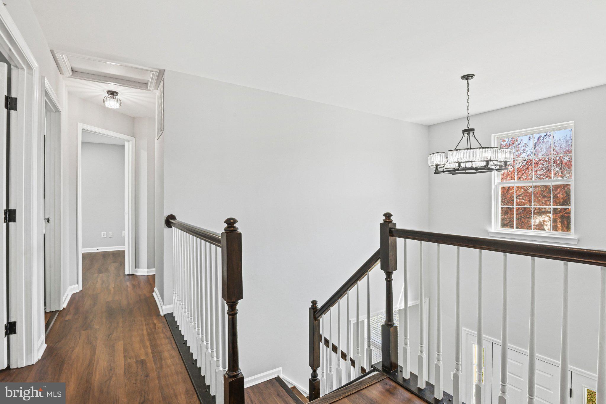 20733 Rainsboro Drive Ashburn, VA 20147 - Photo 29 of 63 a view of a hallway with wooden floor and stairs