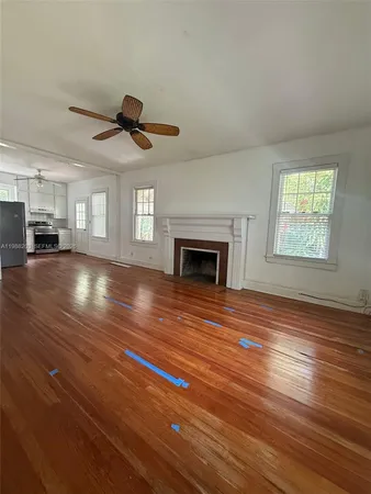 a view of empty room with wooden floor and fireplace