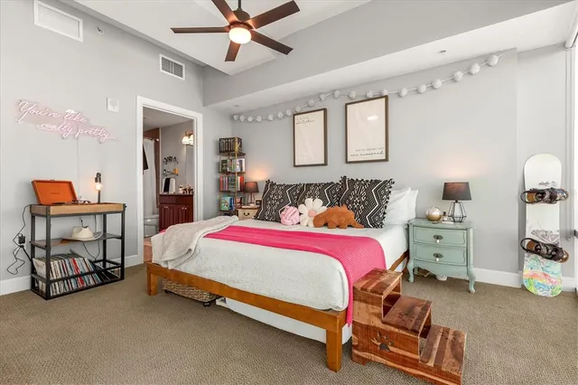 a spacious bedroom with a bed and dresser