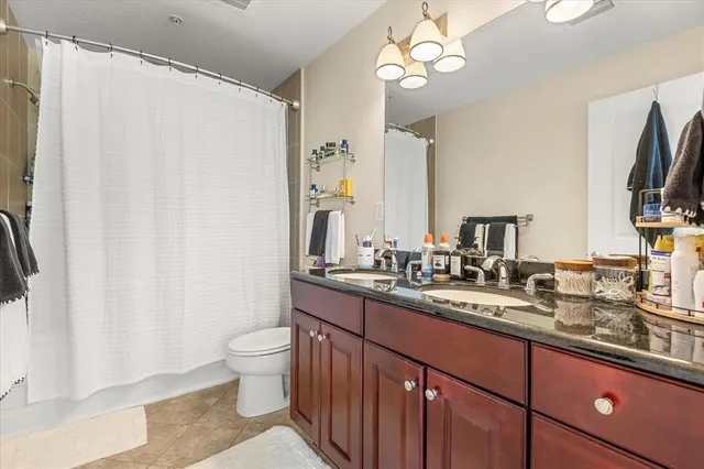 a bathroom with a double vanity sink mirror and toilet