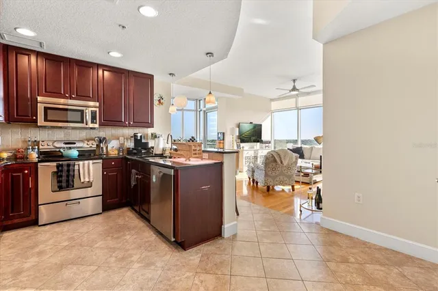 a kitchen with stainless steel appliances granite countertop a stove top oven a sink a counter top space and cabinets