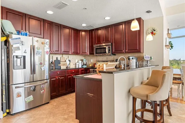 a kitchen with stainless steel appliances granite countertop a refrigerator stove microwave and sink