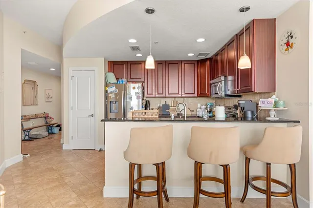 a kitchen with stainless steel appliances granite countertop a stove a sink and a refrigerator