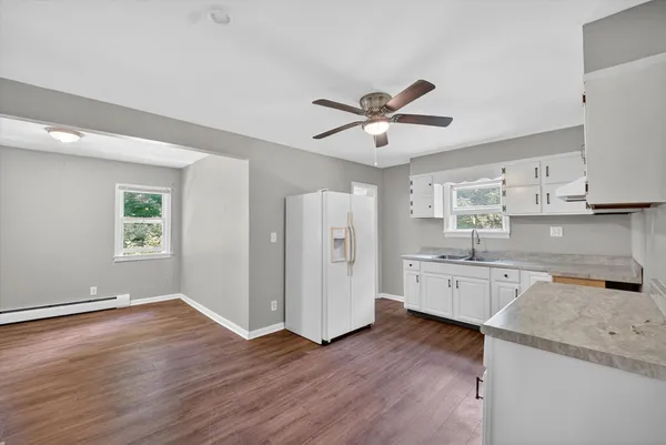 a large kitchen with a wooden floor and a large window