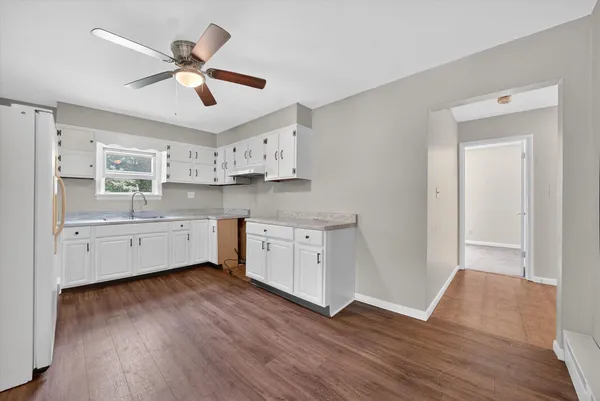 a kitchen with wooden floors and white appliances