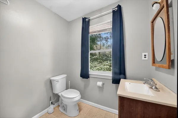 a bathroom with a sink toilet and a mirror