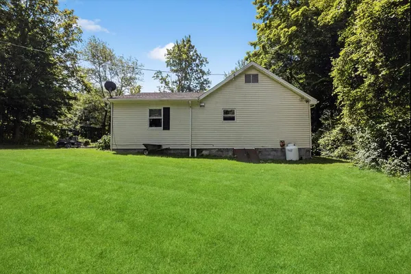 a view of backyard of house with green space