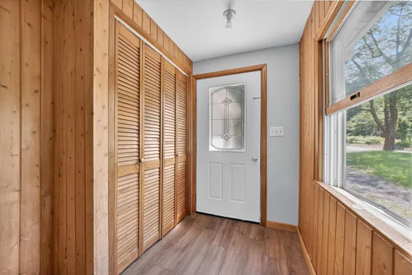 a view of a hallway with wooden floor and windows