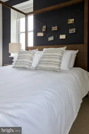 a bedroom with a large bed and a lamp with window