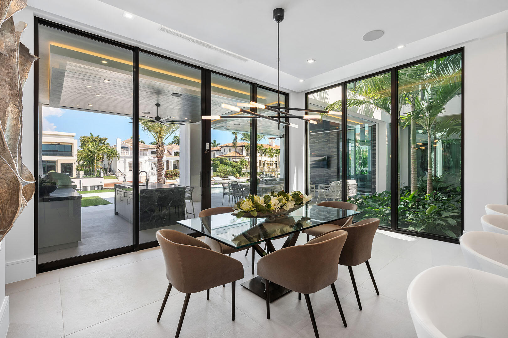 169 Coconut Palm Road Boca Raton, FL 33432 - Photo 19 of 84 a dining room with furniture large windows and a chandelier