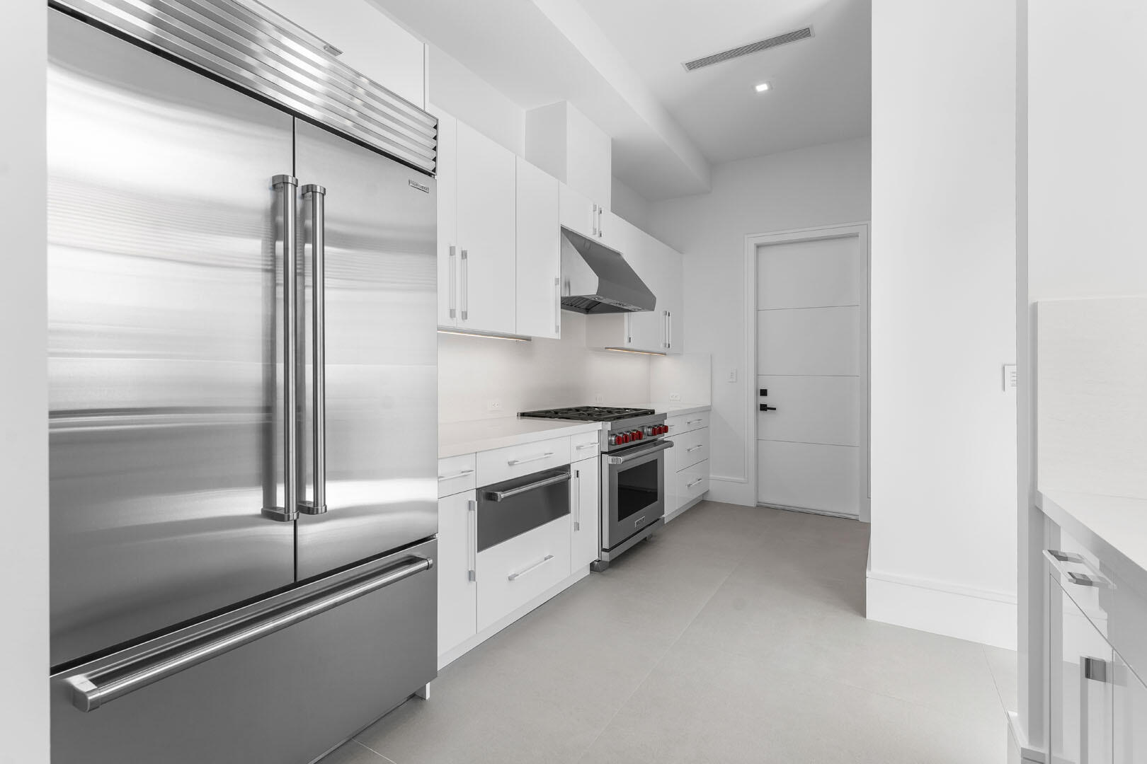 169 Coconut Palm Road Boca Raton, FL 33432 - Photo 21 of 84 a kitchen with stainless steel appliances and white cabinets