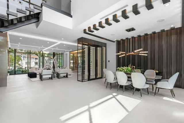 a dining hall with stainless steel appliances granite countertop a stove a refrigerator a dining table and chairs with wooden floor