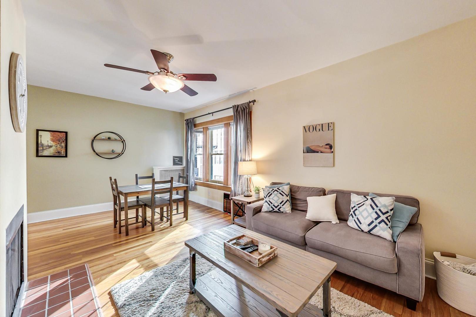 537 West Addison Street, Unit 3S Chicago, IL 60613 - Photo 3 of 19 a living room with furniture a clock on a desk and a window