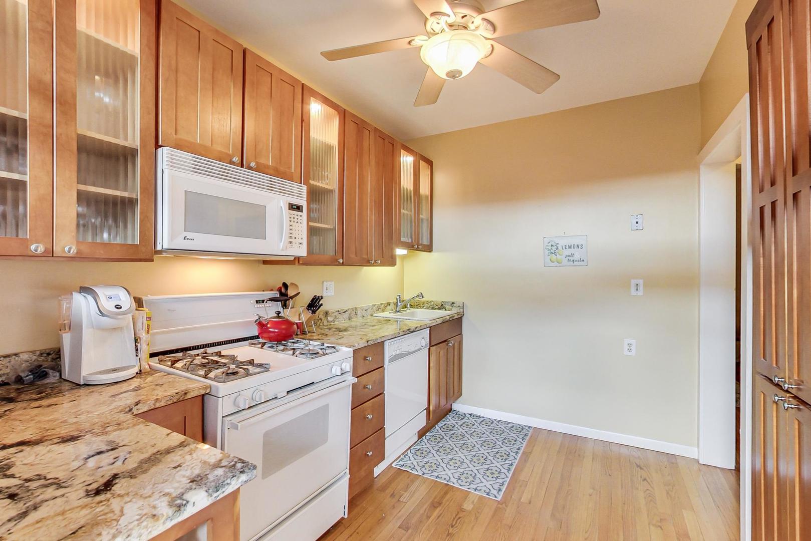 537 West Addison Street, Unit 3S Chicago, IL 60613 - Photo 9 of 19 a kitchen with a stove cabinets and wooden floor