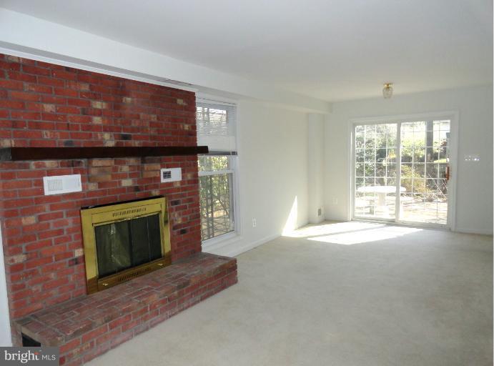 8711 Victoria Road Springfield, VA 22151 - Photo 3 of 15 a living room with a fireplace a flat screen tv and a fireplace