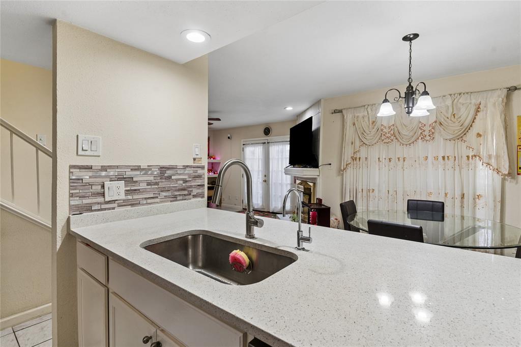 11311 Audelia Road, Unit 102 Dallas, TX 75243 - Photo 11 of 31 Kitchen featuring a stainless steel sink, gooseneck faucet, light-toned countertop, and mosaic tile backsplash