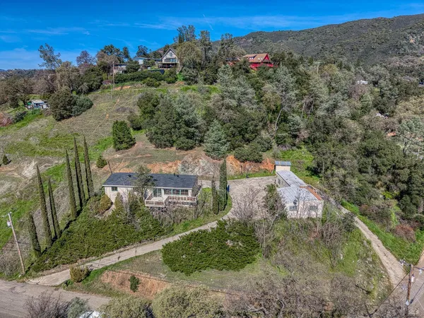 an aerial view of a house with a mountain