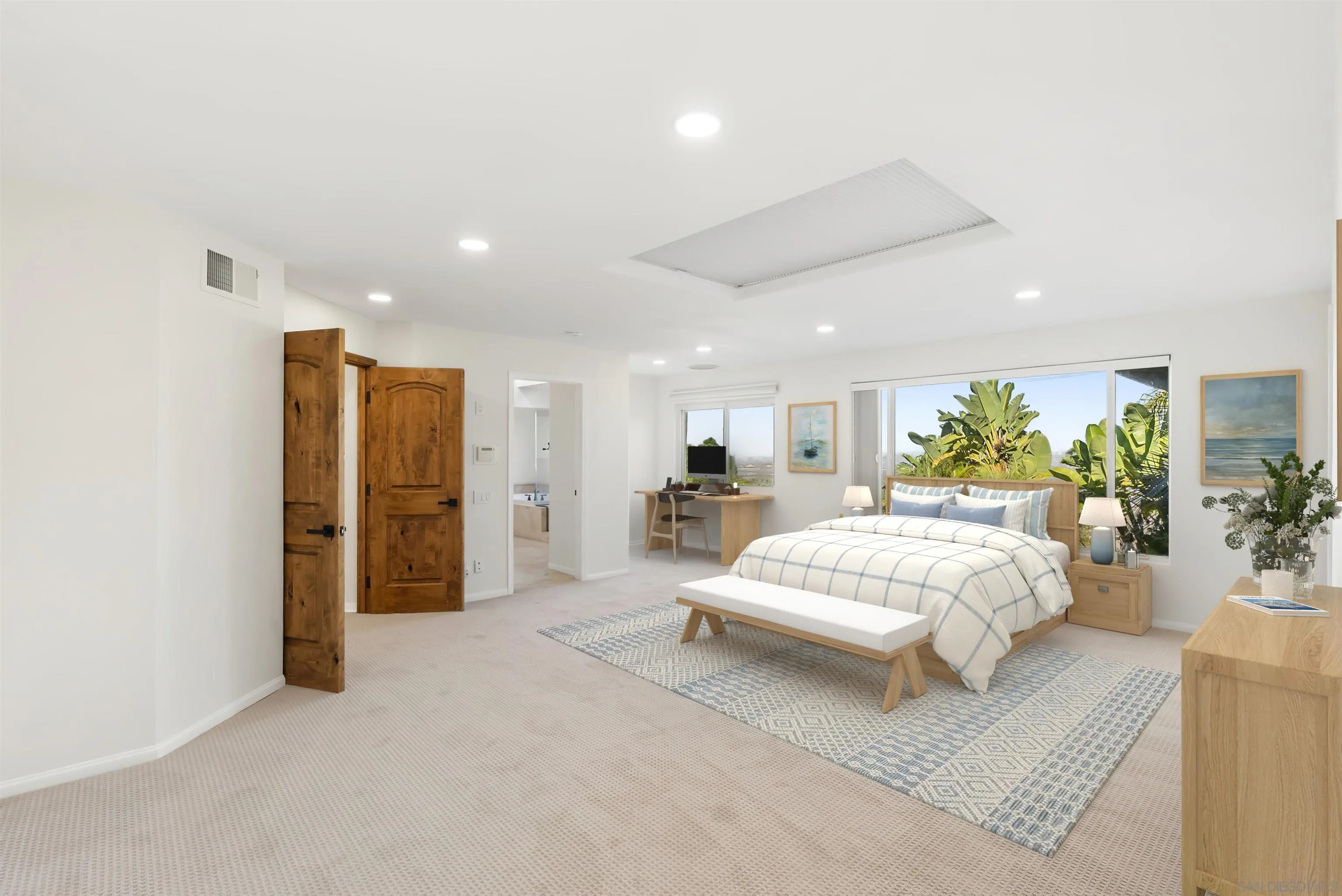 13404 Kibbings Road San Diego, CA 92130 - Photo 17 of 32 a spacious bedroom with a large bed and a chandelier