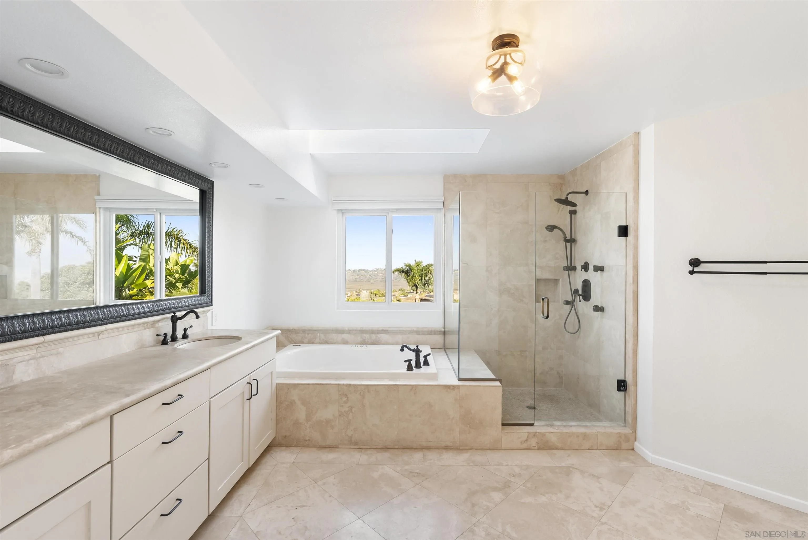 13404 Kibbings Road San Diego, CA 92130 - Photo 19 of 32 a spacious bathroom with a tub sink and mirror