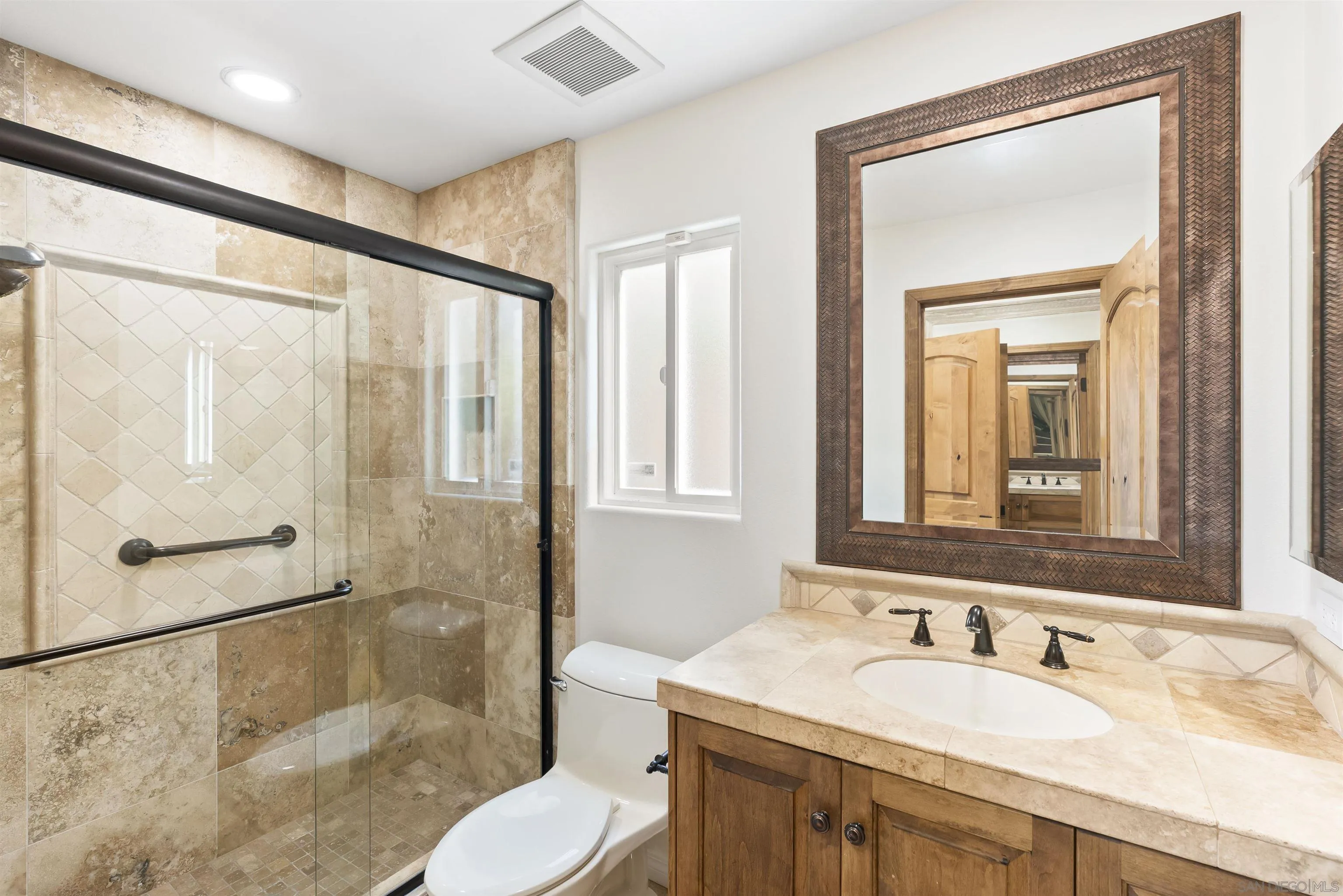 13404 Kibbings Road San Diego, CA 92130 - Photo 24 of 32 a bathroom with a granite countertop sink toilet and shower