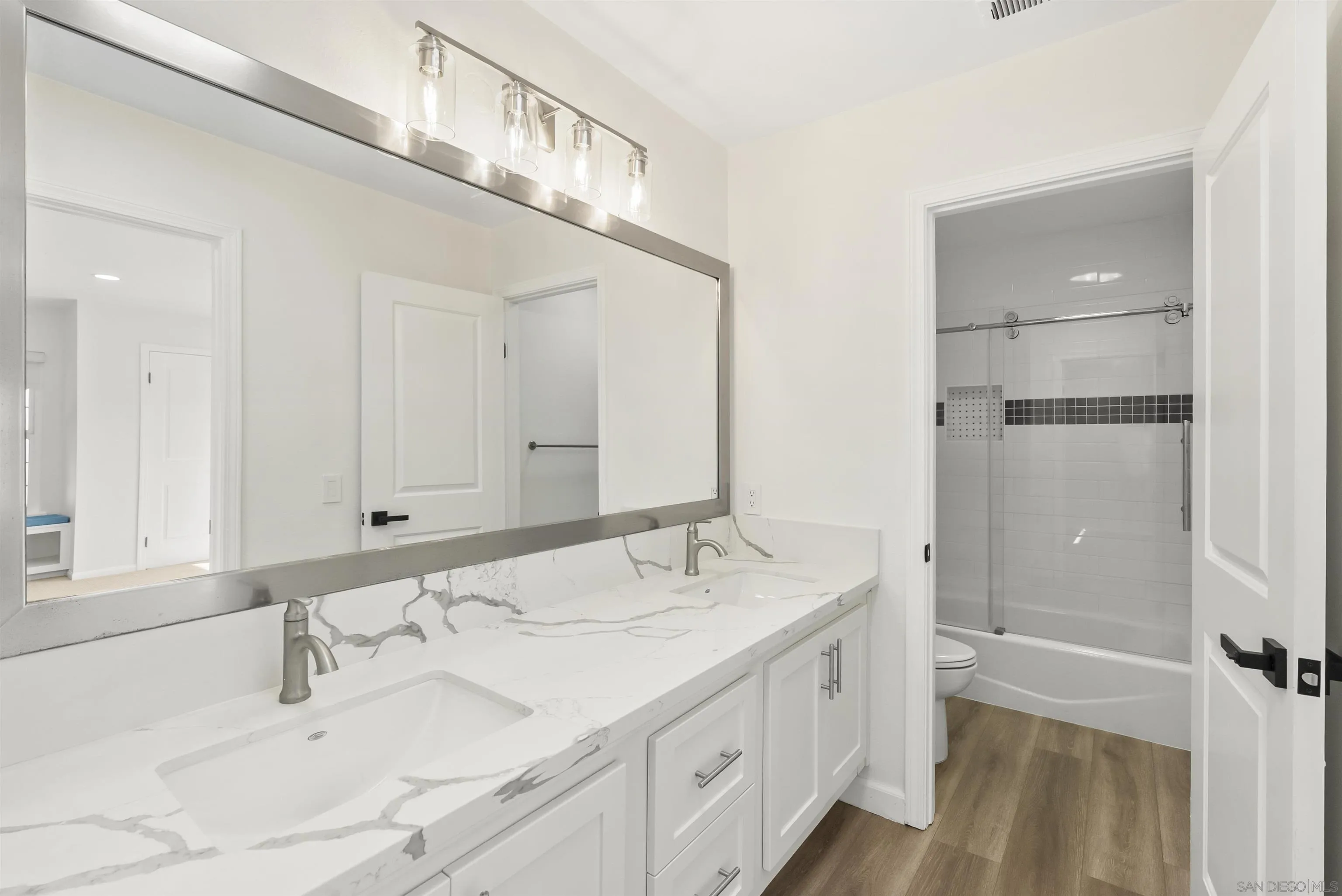 13404 Kibbings Road San Diego, CA 92130 - Photo 27 of 32 a bathroom with a double vanity sink a mirror and a shower