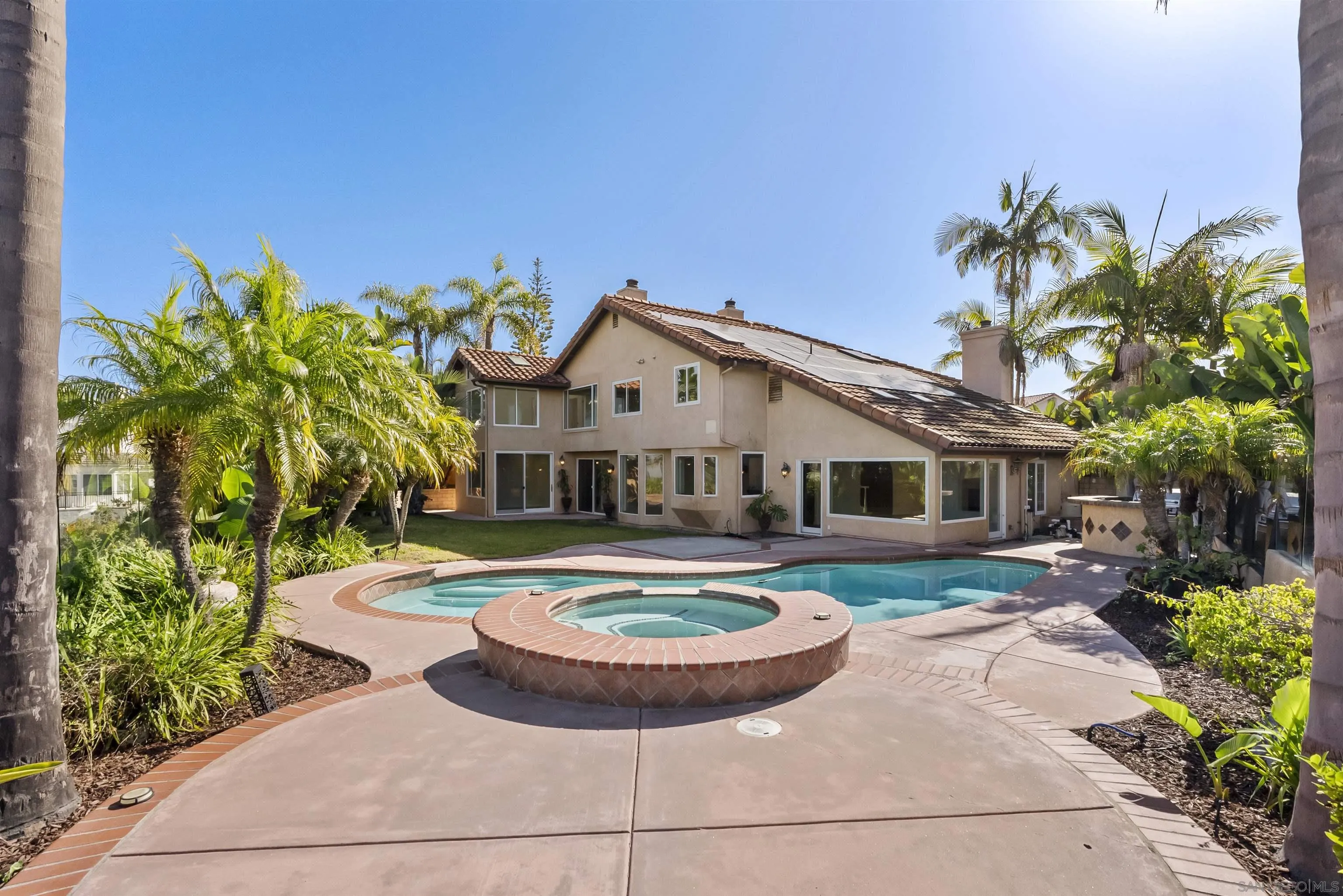 13404 Kibbings Road San Diego, CA 92130 - Photo 3 of 32 a front view of a house with a garden and swimming pool