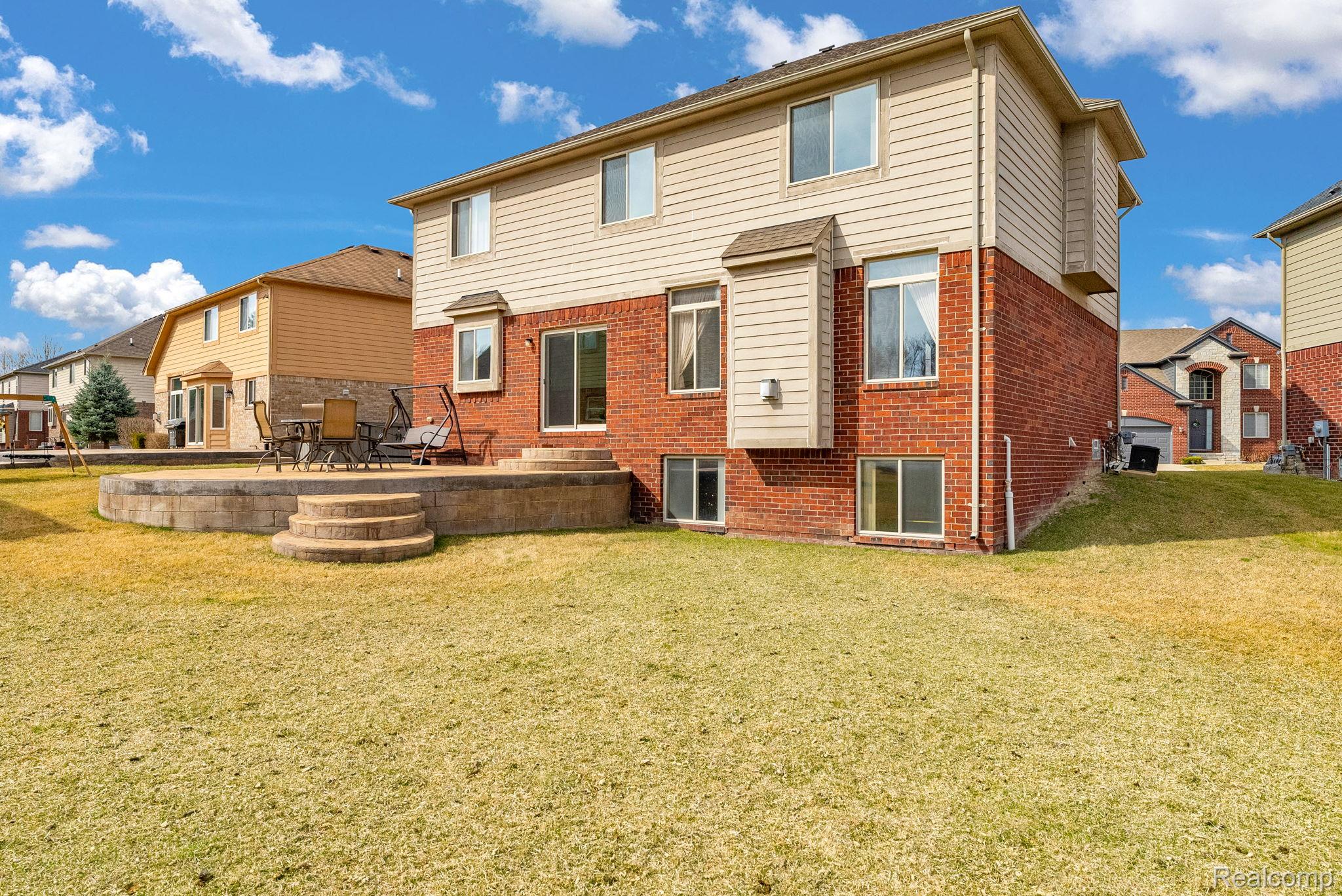 4122 Hawks Nest Road Utica, MI 48317 - Photo 64 of 74 Rear view of house with brick siding, a patio, a yard, and a residential view