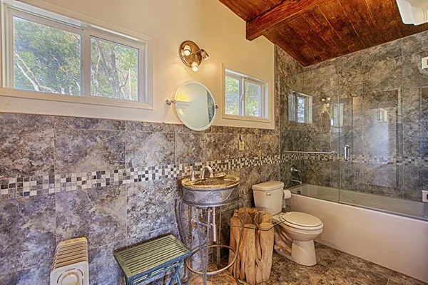a bathroom with a toilet a sink and mirror