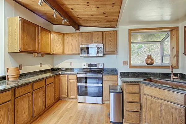 a kitchen with stainless steel appliances granite countertop a stove sink and cabinets