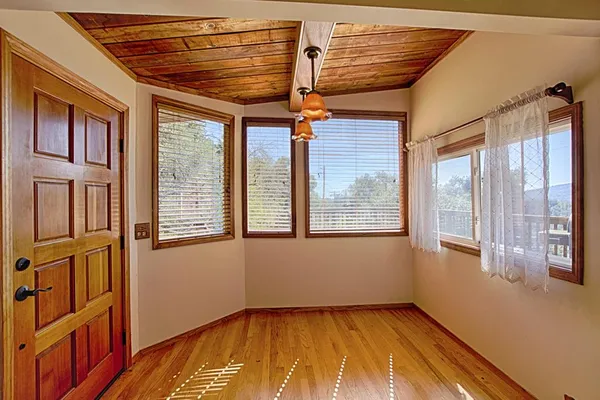 a view of an empty room with a window and wooden floor