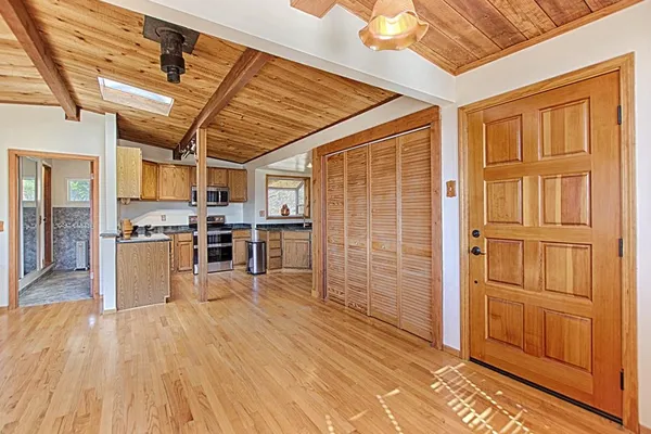 a view of kitchen with stainless steel appliances wooden floor and large windows