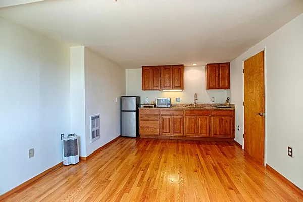 a kitchen with stainless steel appliances granite countertop a stove a sink dishwasher and a refrigerator with wooden floor