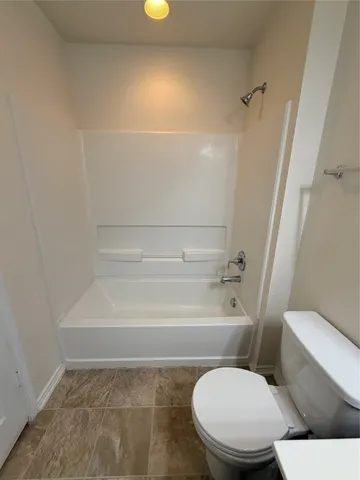 a bathroom with a toilet and a bath tub