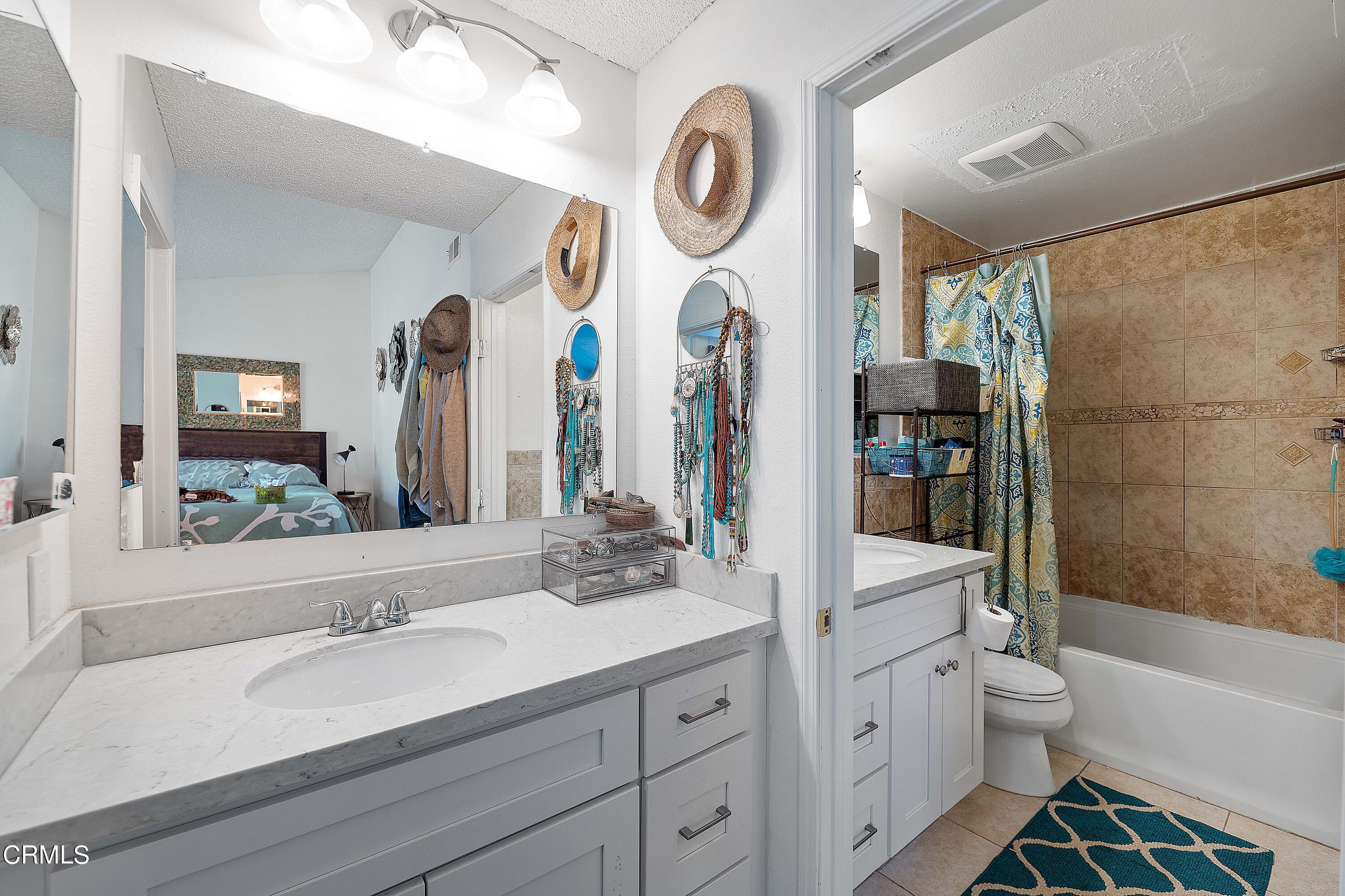 5319 Perkins Road Oxnard, CA 93033 - Photo 21 of 24 a bathroom with a bathtub a sink and a large mirror