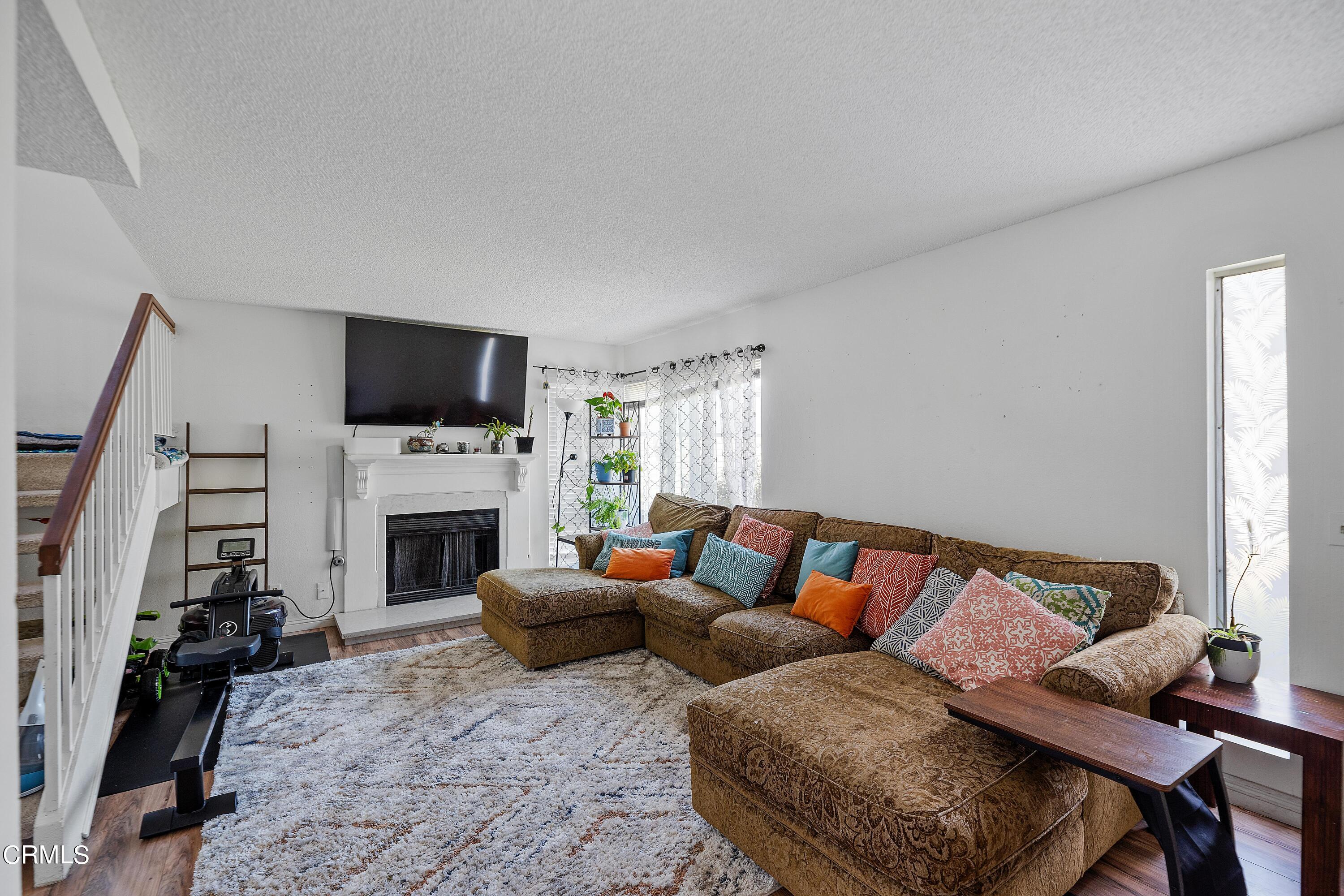 5319 Perkins Road Oxnard, CA 93033 - Photo 6 of 24 a living room with furniture a flat screen tv and a fireplace