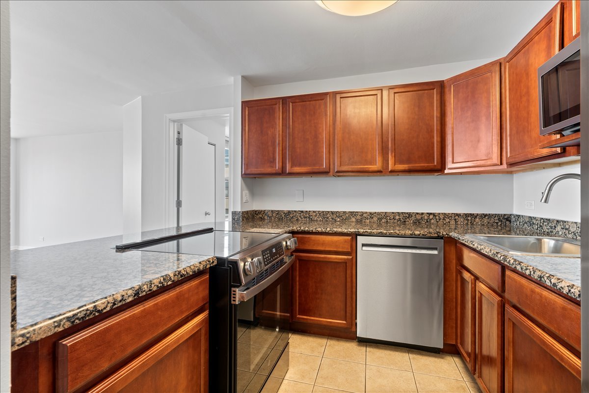 525 West Hawthorne Place, Unit 808 Chicago, IL 60657 - Photo 7 of 29 a kitchen with granite countertop a sink stove and cabinets