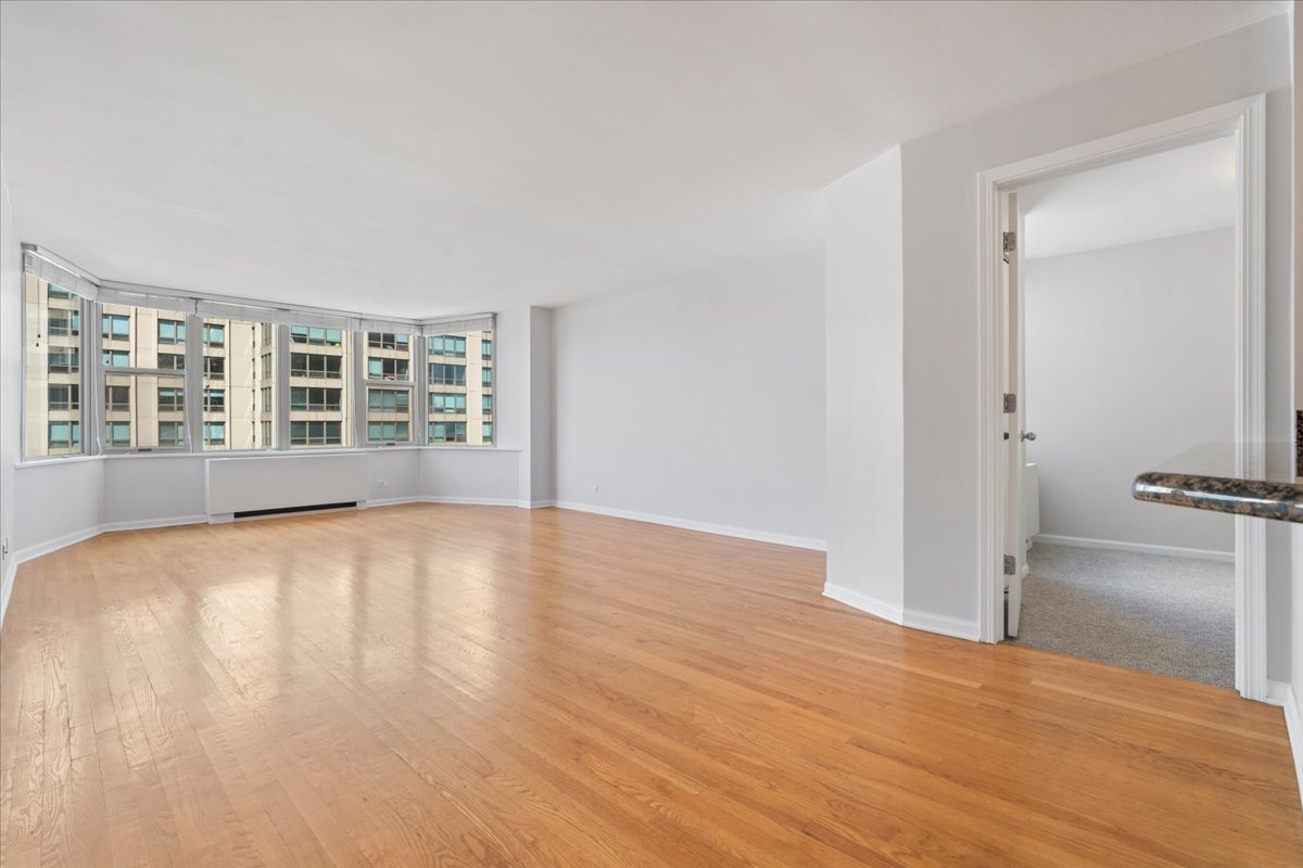 525 West Hawthorne Place, Unit 808 Chicago, IL 60657 - Photo 10 of 29 a view of an empty room with a window and wooden floor