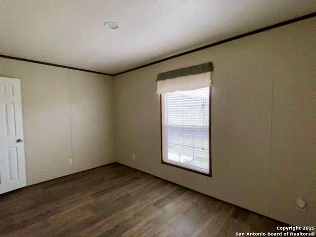 13009 Annette Road Angleton, TX 77515 - Photo 10 of 14 an empty room with wooden floor and windows