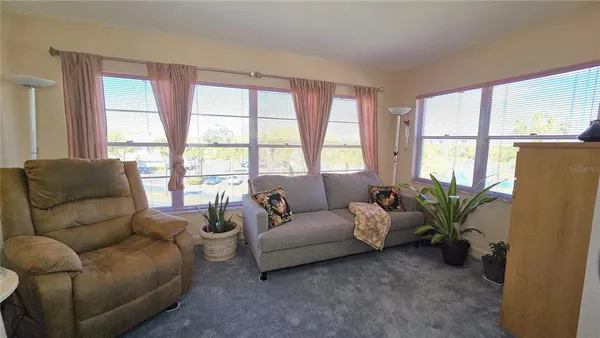 a living room with furniture and large windows