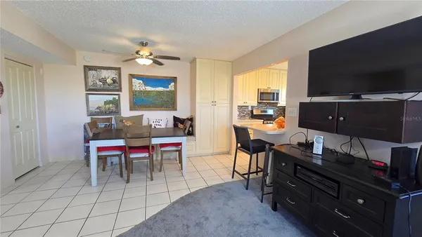 a living room with furniture a flat screen tv and kitchen view