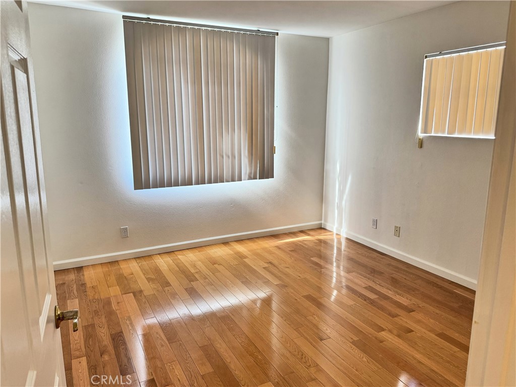 18319 Hart Street, Unit 3 Reseda, CA 91335 - Photo 12 of 18 a view of an empty room with wooden floor and a window