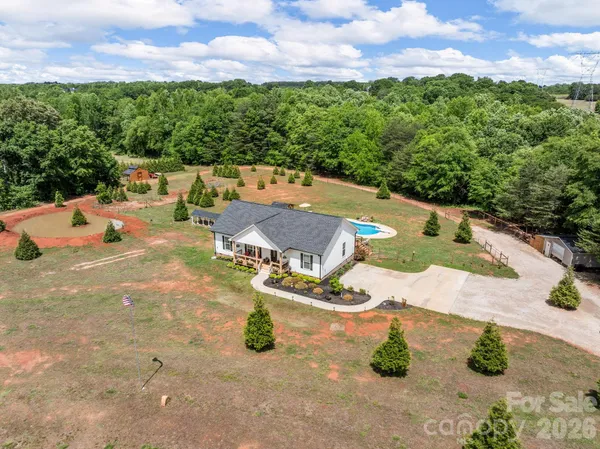 an aerial view of a house with yard swimming pool and outdoor seating