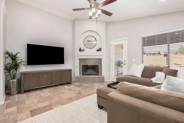a living room with furniture a flat screen tv and a fireplace