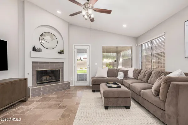 a living room with furniture a large window and a fireplace