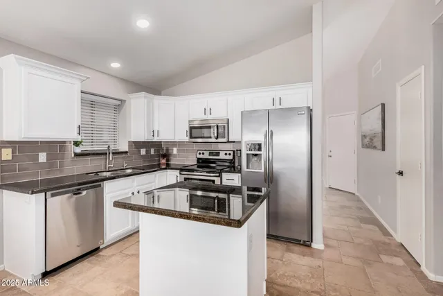 a kitchen with granite countertop a refrigerator and a sink
