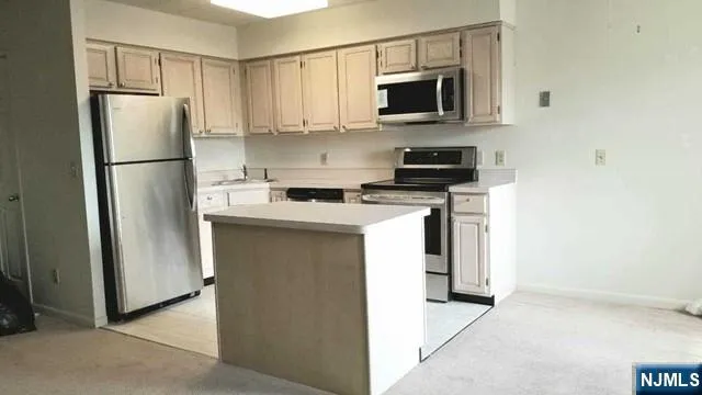 a kitchen with stainless steel appliances granite countertop a refrigerator stove a microwave and a sink